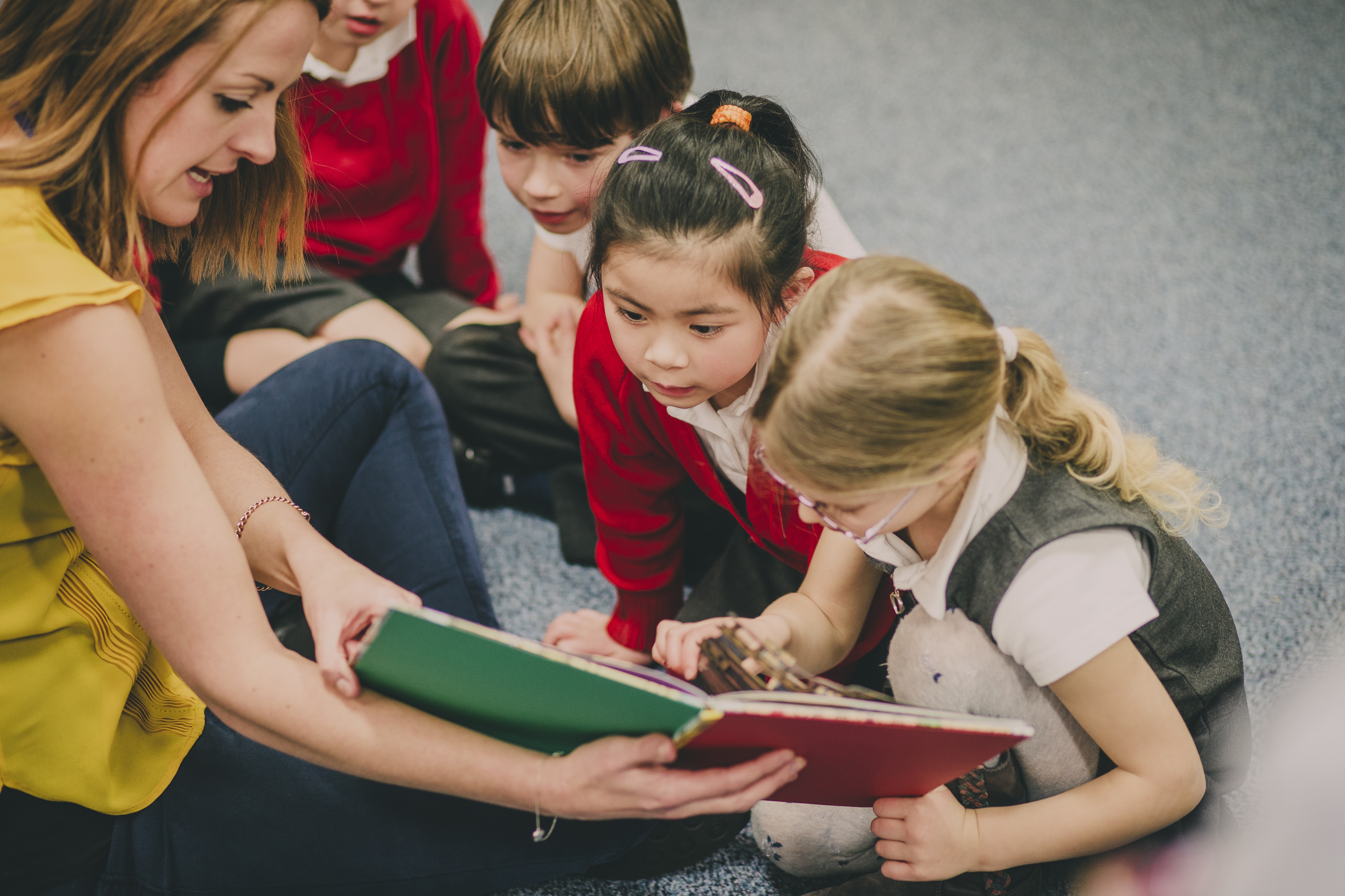 Group of children with a teacher and book