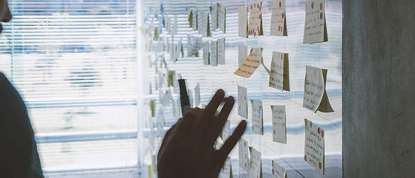 Man placing post-it notes on wall