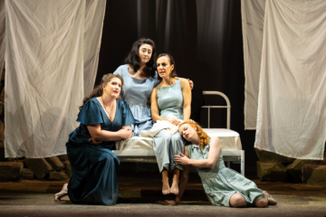 Lucretia, Female Chorus, Lucia and Bianca embrace while sitting on Lucretia's bed and singing.