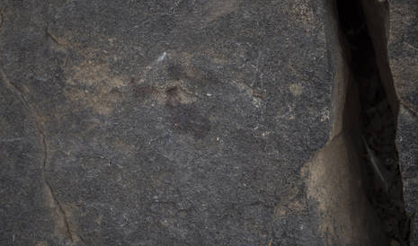 Photo: A bloody handprint stains a vertical rock surface. (Greg Marinovich)