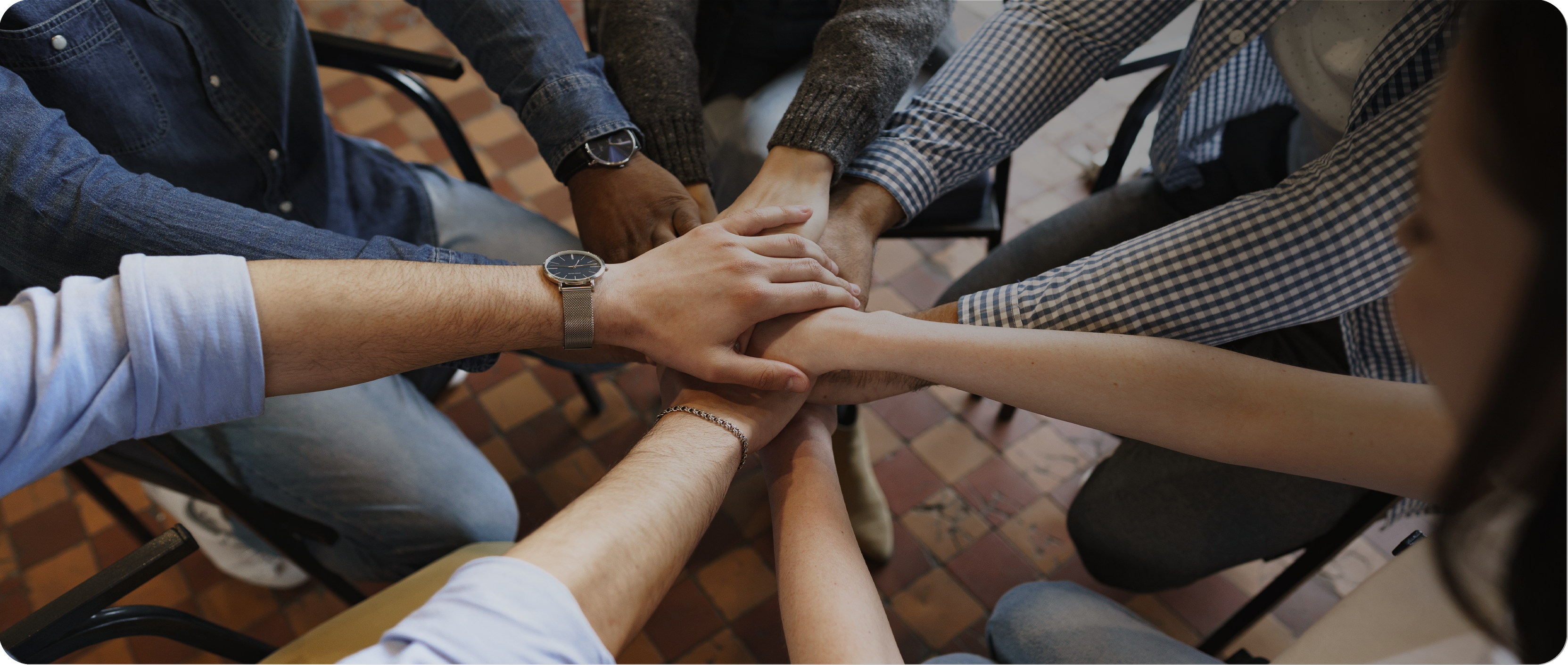 many hands from diverse team members joining together