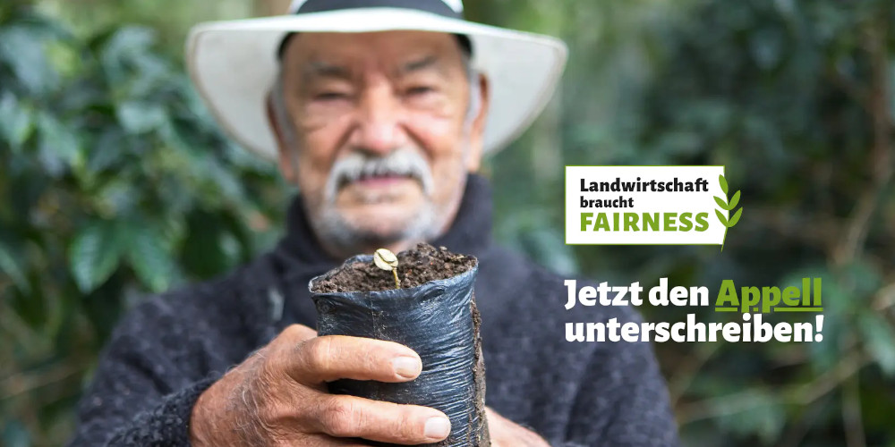 Bärtiger Bauer hält einen Kaffeesetzling in die Kamera, daneben der Schriftzug: "Landwirtschaft braucht Fairness. Jetzt den Appell unterschreiben!"