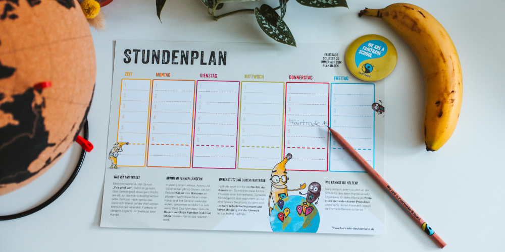 Fairtrade-Schools Give Aways: Stundenplan, Bleistift, Button. danaben: eine banane und ein Globus