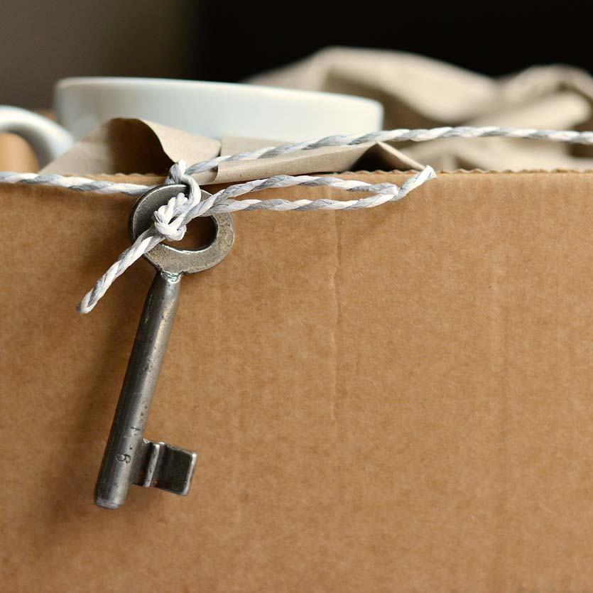 Umzugskarton mit Tasse und Schlüssel