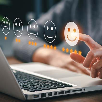 Hände vor Laptop wählen Bewertung Smiley aus