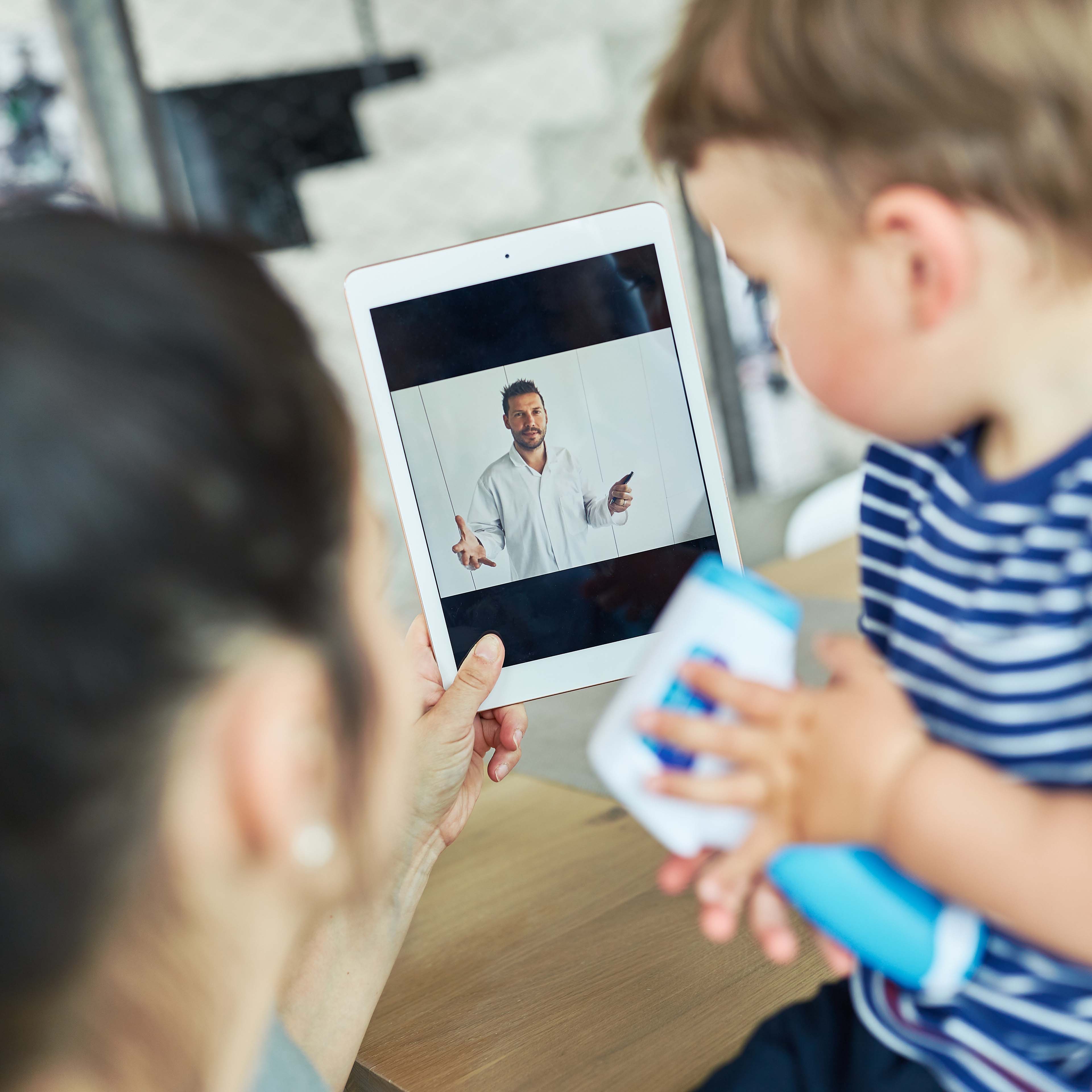 Mutter und Kind in Videosprechstunde mit Arzt