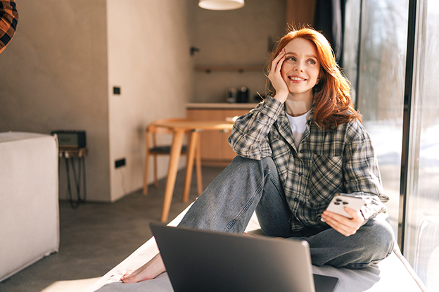 Frau mit Laptop am Fenster