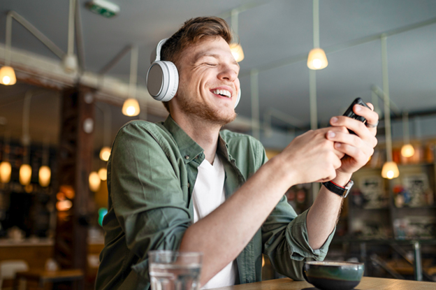 Mann guckt aufs Handy und freut sich