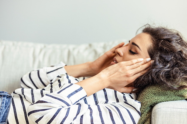 Frau mit Frau auf der Couch mit Kopfschmerzenam See