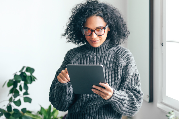 Frau guckt aufs Tablet und informiert sich