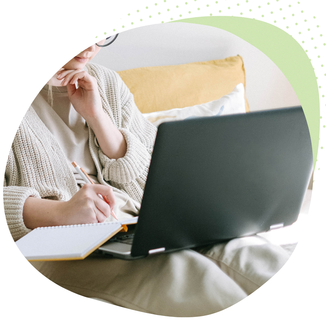 Frau am Laptop mit Stift und Notizbuch