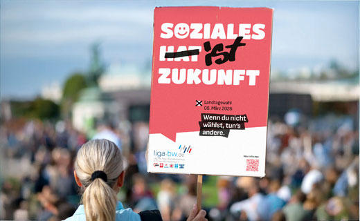 Eine Frau hält ein Plakat mit dem Kampagnenmotiv der Liga BW hoch