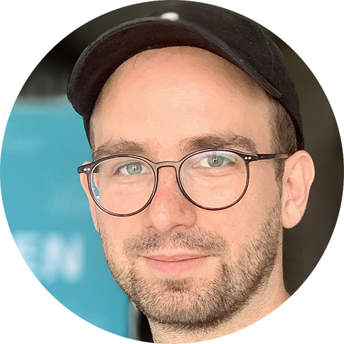 junger Mann mit runder Brille, Bart und Kappe