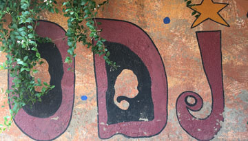 An der Wand steht in roten Buchstaben und mit gelbem Stern ODJ, darüber wächst leicht Efeu