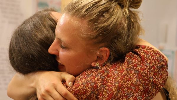 Auf dem Foto sieht man zwei Frauen, die sich herzlich umarmen.