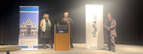 Auf diesem Foto sehen Sie in der Mitte den Vorsitzenden des Integrationsrates, Recep Alpan. Rechts und links von ihm stehen die Referentin Judith Herbe und die Mitorganisatorin des Abends, Sarah Kaas.