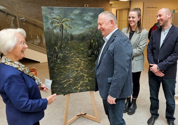 Menschen stehen vor einem Bild und unterhalten sich.