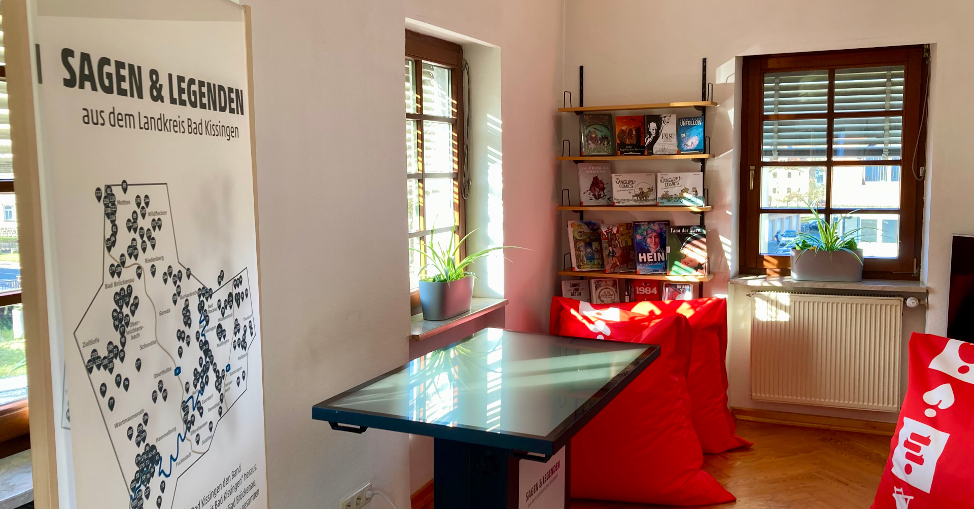 Ansicht eines Infobanners und eines digitalen Medientisches in einer Bücherei