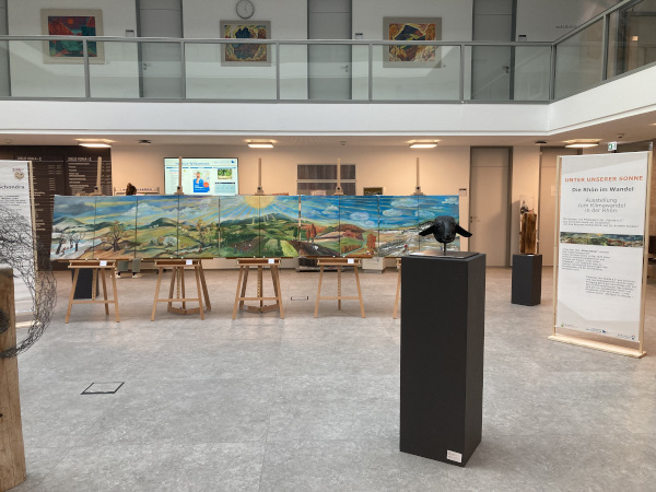 Bilder auf Staffeleien sowie Skulpturen auf Sockeln