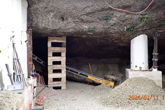 Mit Betonstützen und provisorischen Holzstützen abgesicherte Kammerdecke in einem Bergwerk.