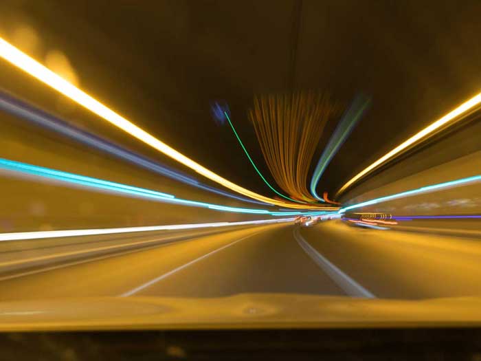 Langzeitaufnahme eines erleuchteten Autotunnels. 