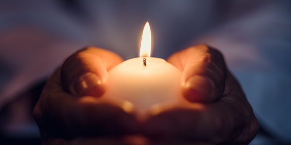 Kerze in den Händ gehalten
