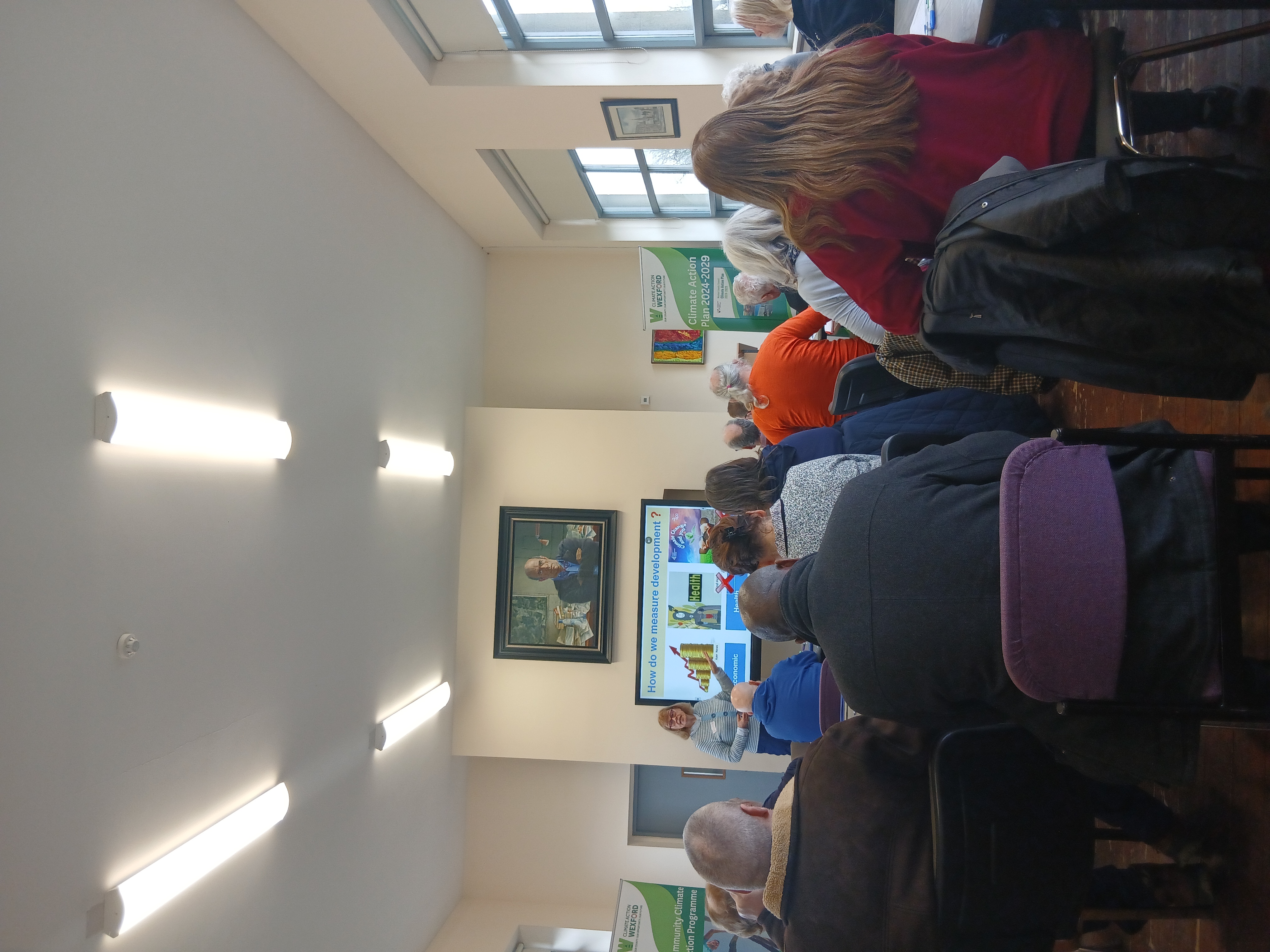 Image of people sitting on chairs looking at a tutor/screen