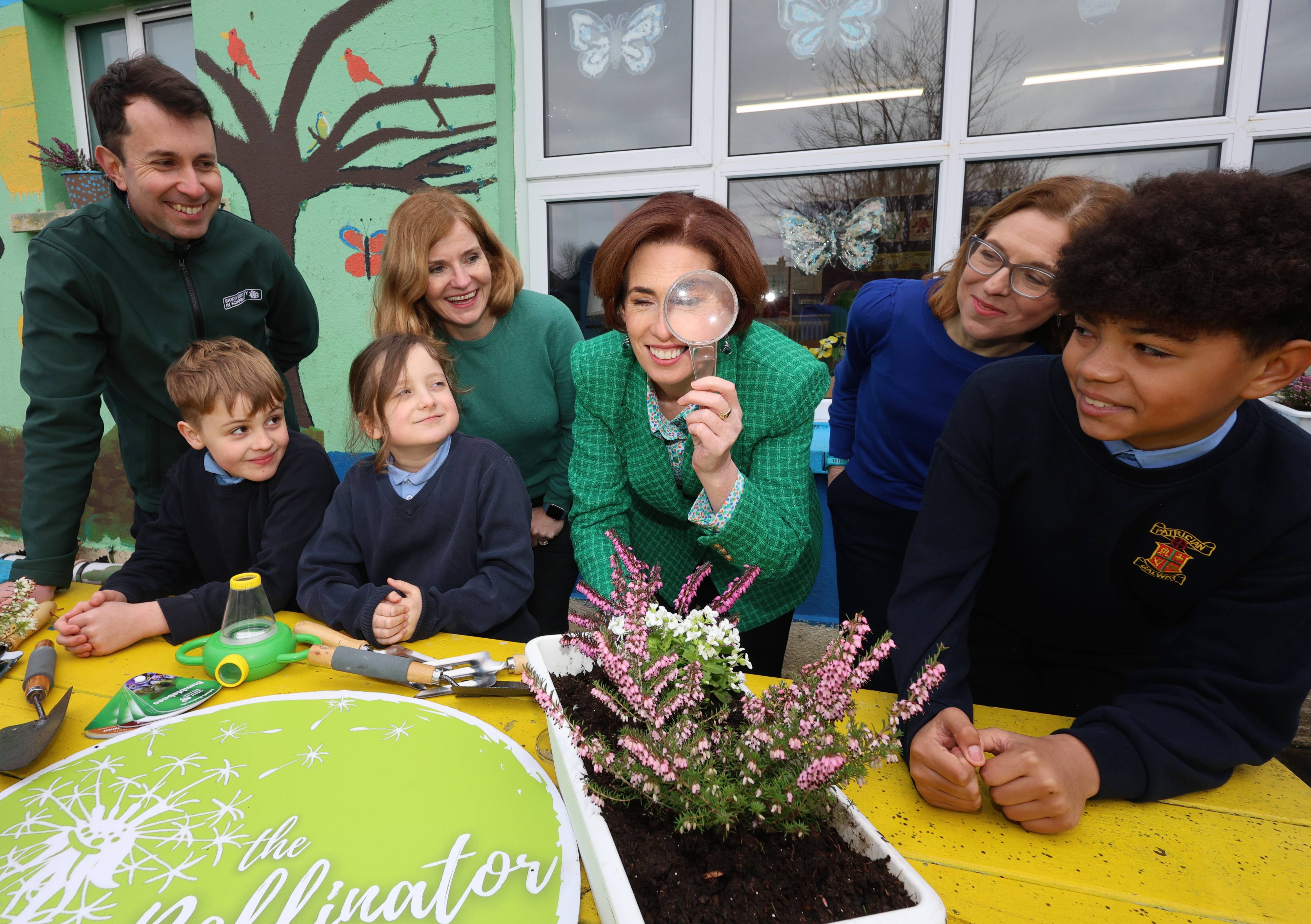A group of people gathered around a table examining a plant