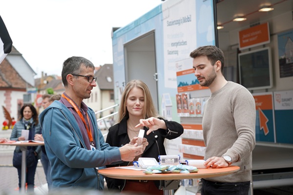 Das Foto zeigt eine Beratungssituation vor dem Sanierungsmoibil.