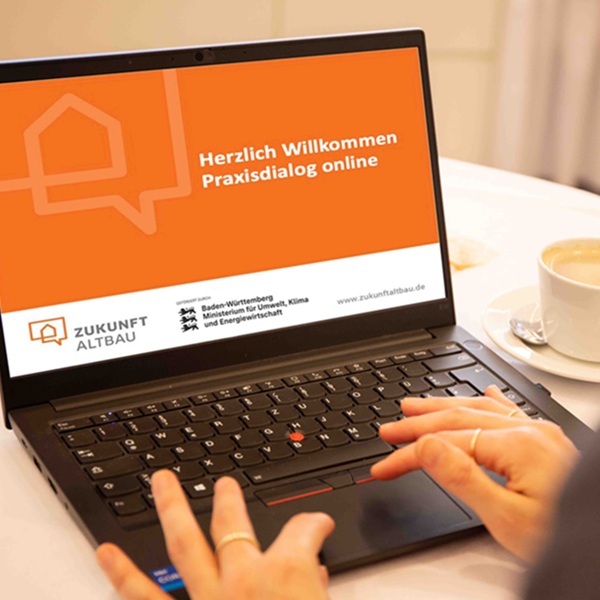 Das Bild zeigt einen Laptop mit einer Präsentation, die zum Praxisdialog begrüßt.