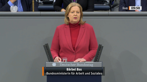 Bundesministerin Bärbel Bas steht im Plenarsaal des Bundestages am Rednerpult.