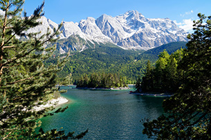 Sportlich aktiv und relaxed an der Zugspitze Wanderweg mit Blick auf den malerischen türkisfarbenen Alpensee Eibsee am Fuße der Zugspitze in Bayern