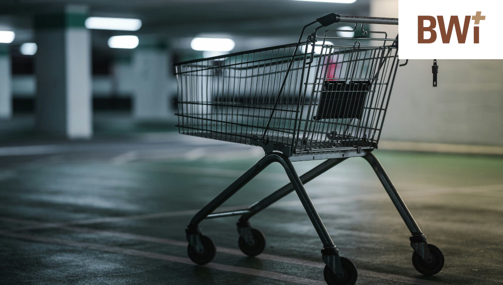 Empty shopping trolley in a dimply lit, empty underground car park (Photo: James Watson on Unsplash)