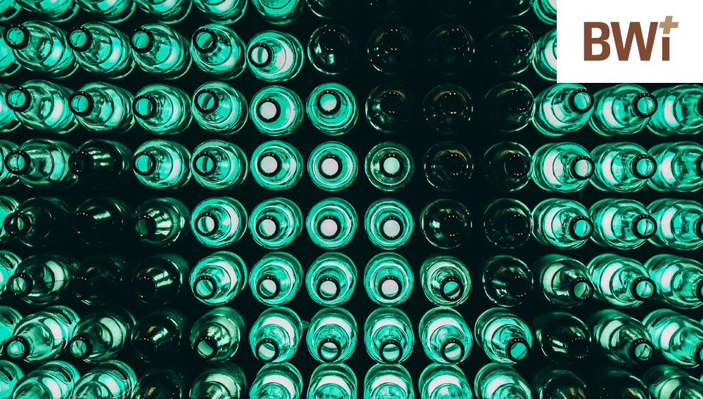 Empty glass bottles photographed from above; some of them are highlighted from below with green LED light (Photo: Ameer Basheer on Unsplash)