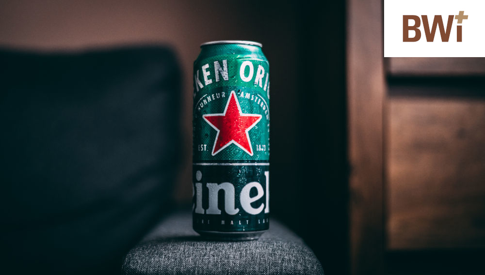 Green Heineken can on the arm of a bluish-grey sofa (Photo: Marko Blažević on Unsplash)