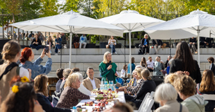 Frau spricht an Tafel im Freien