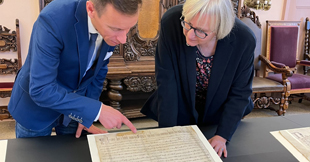 Zwei Personen beugen sich über Dokument