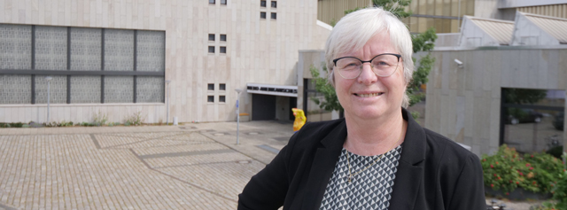 Frau posiert vor Gebäude