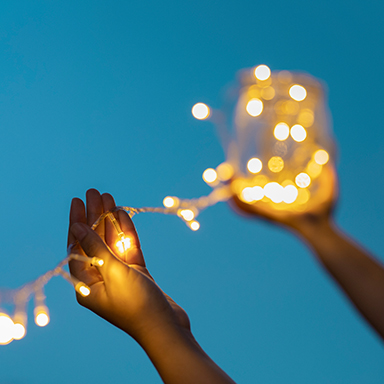 Hände halten eine leuchtende Lichterkette