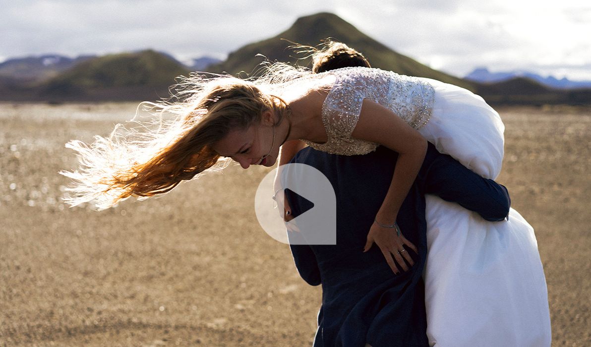 Bräutigam trägt die Braut in einer Landschaft über der Schulter