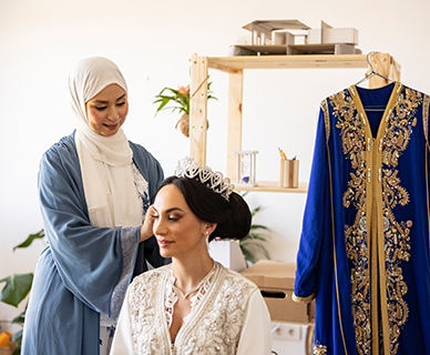 Muslimin befestigt bei einer Braut den Kopfschmuck
