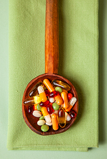 Bunte Pillen auf einem Holzlöffel