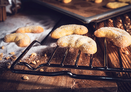 Frisch gebackene Vanillekipferln auf einem Backrost