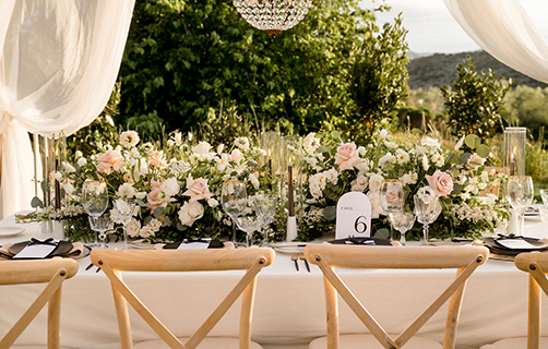 Blumenreich dekorierte Hochzeitstafel in einem Garten