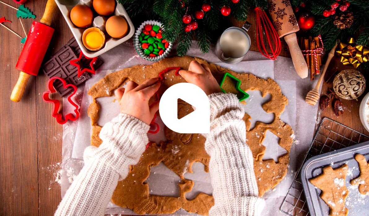 Kinderhände stechen mit bunten Formen Weihnachtsplätzchen aus