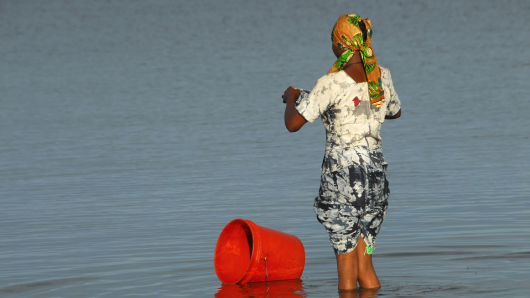 Woman washing laundry in a lake in Africa (Photo: AdobeStock)