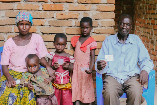 Family with health insurance cards in Tanzania (Photo:  D. Powell, Swiss TPH)