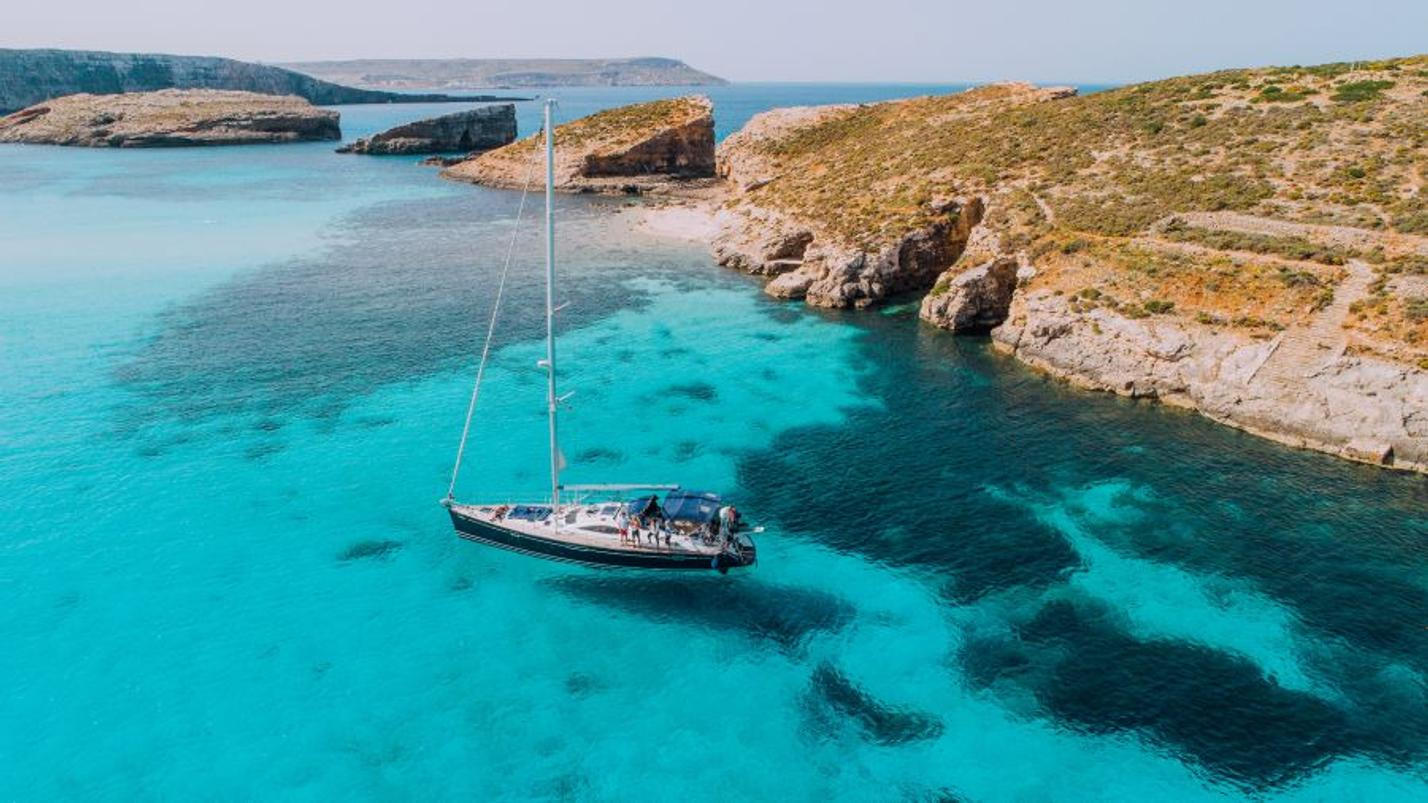 Aerial of Yacht in Blue Lagoon, off Comi