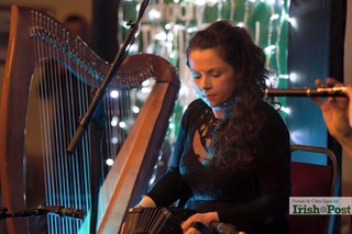 Michelle Mulcahy playing concertina with harp beside her
