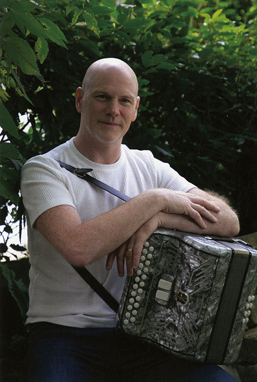 Gerald Culhane seated with a button accordion